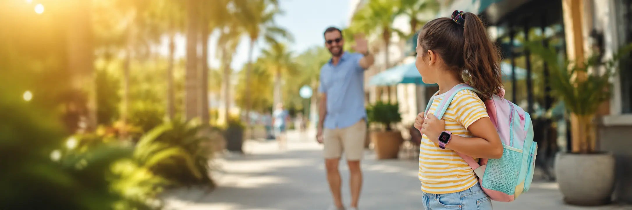 Father waving goodbye to his daughter while she wears a Lil Tracker GPS watch