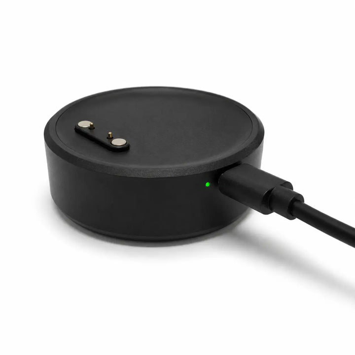 Lil Tracker portable charging dock plugged in with green charging indicator light